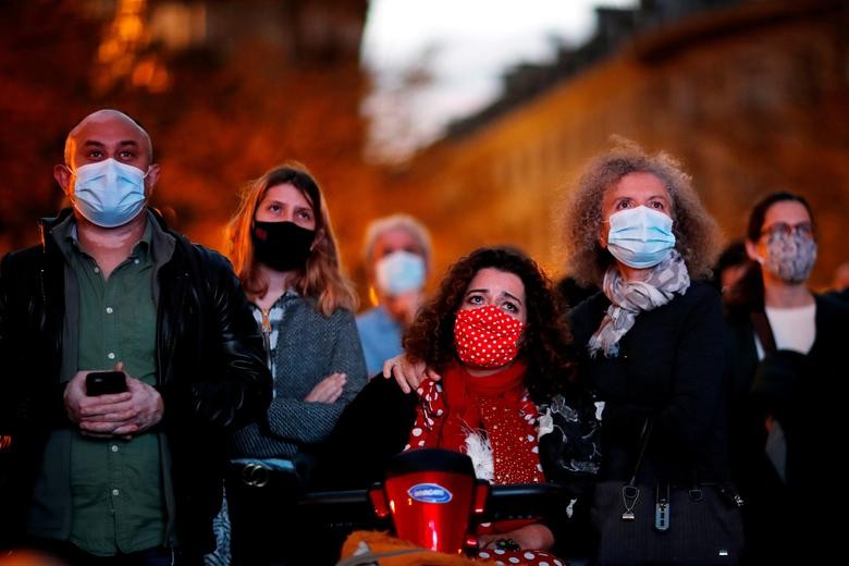 People gather to pay homage to Samuel Paty, the French teacher who was beheaded in the Paris suburb of Conflans-Sainte-Honorine, as part of a national tribute, at the French prestigious university La Sorbonne in Paris, France. REUTERS/Gonzalo Fuentes    